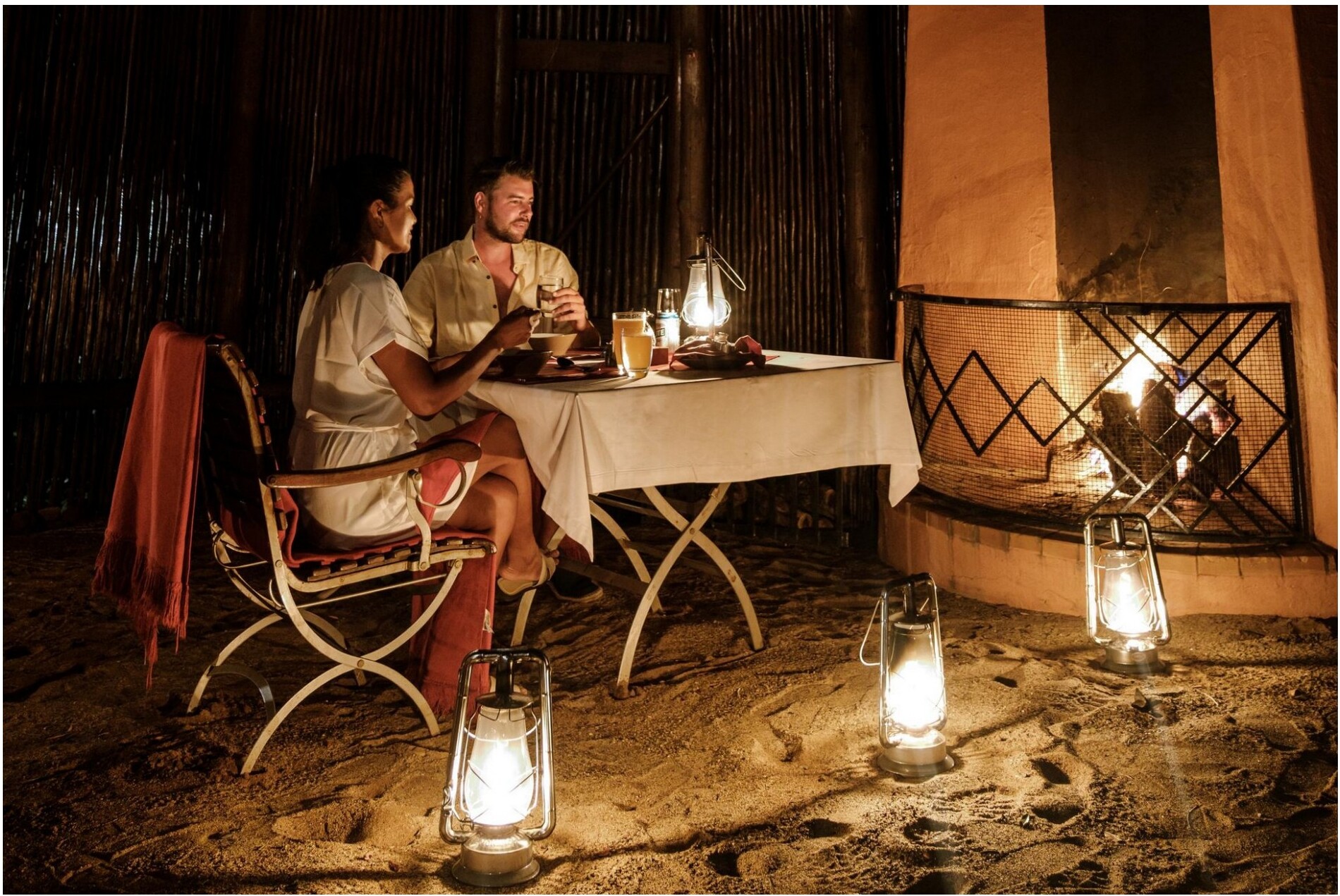 A couple dining quietly by a fireplace at night