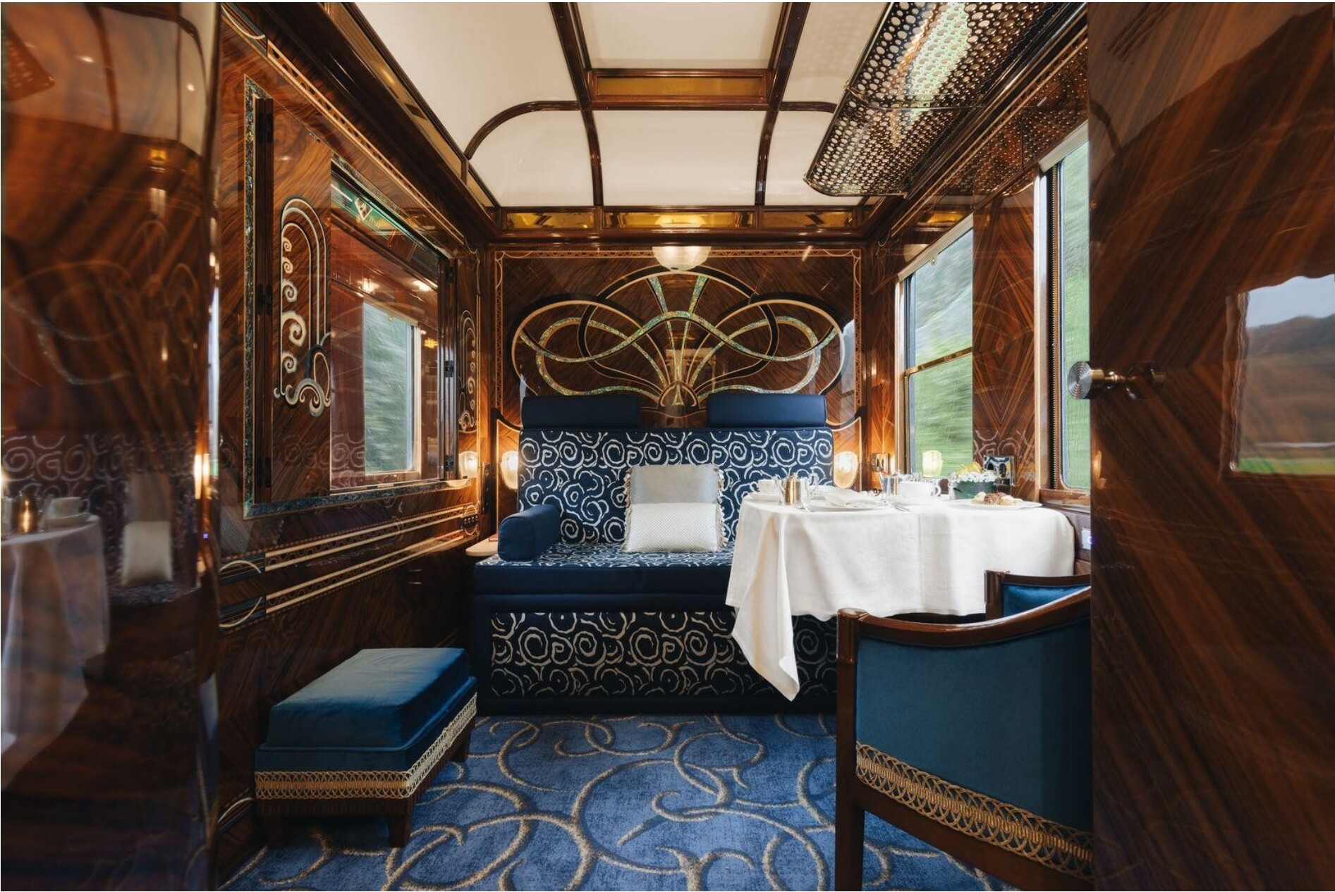 Interior of a luxurious Venice Simplon-Orient-Express carriage with wood paneling and a set dining table