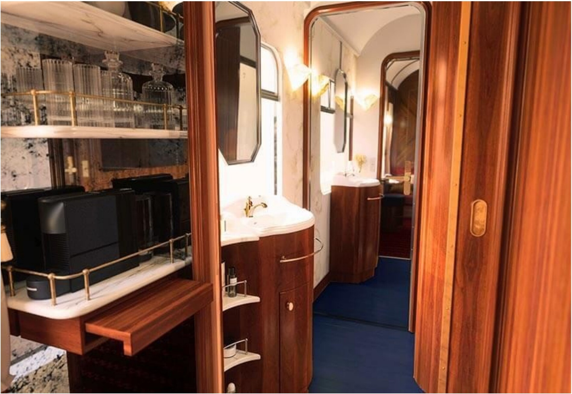 The interior of a luxurious train car with wooden paneling and a vanity area.