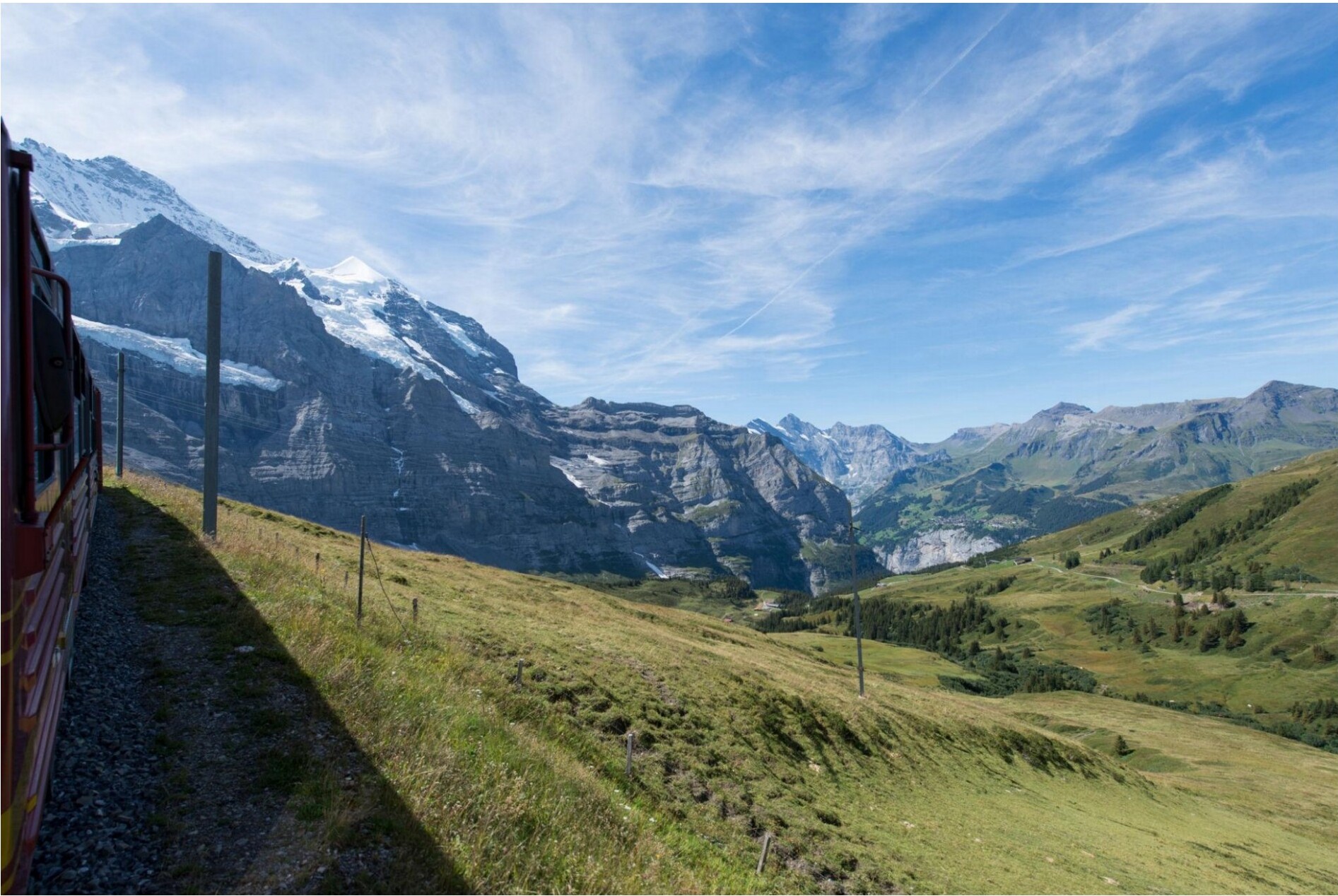 A train traveling through a mountainous landscape with snow-capped peaks.