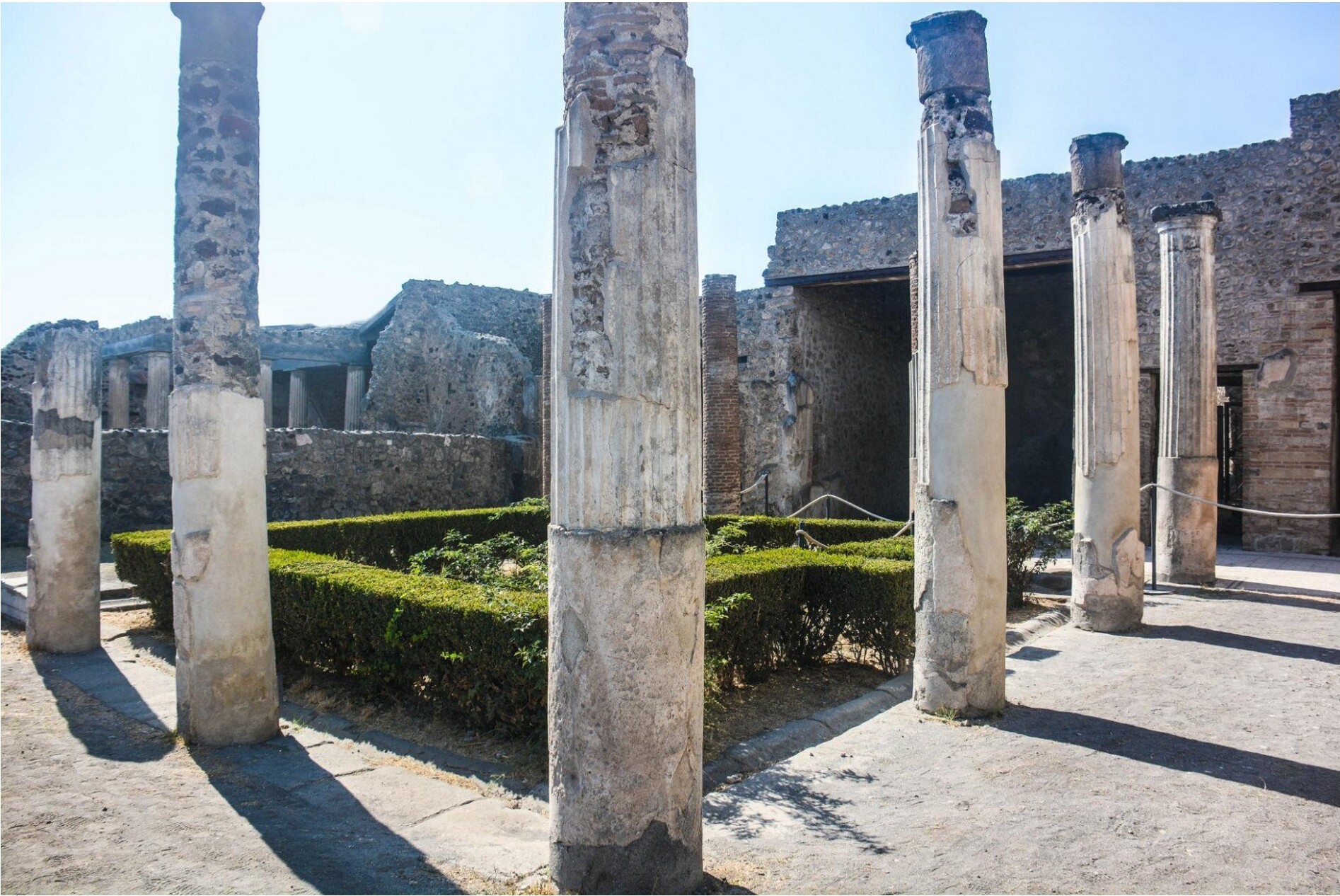 Ancient ruins of Pompeii with columns and hedges