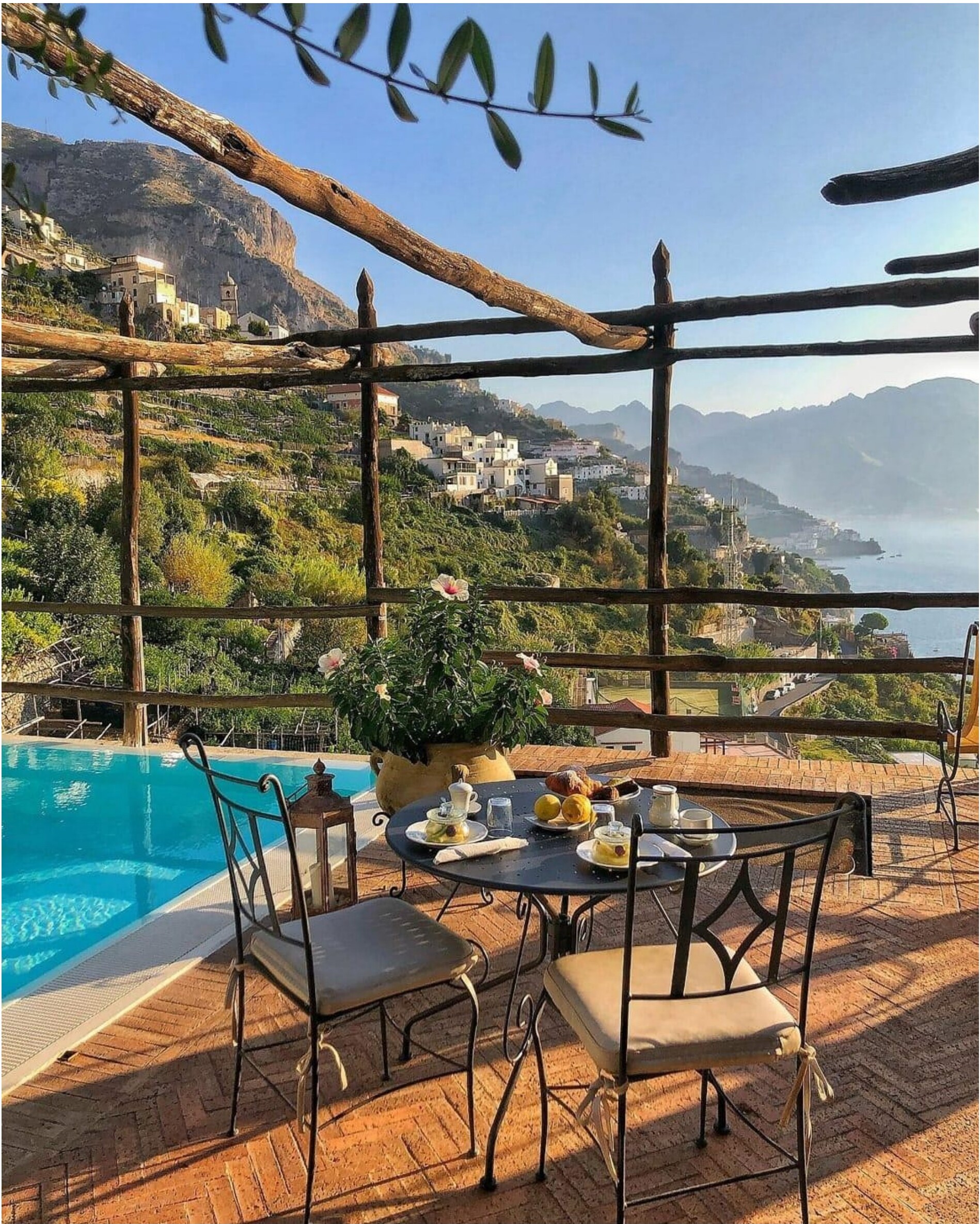 Terrace with a pool and a view of a coastal town.