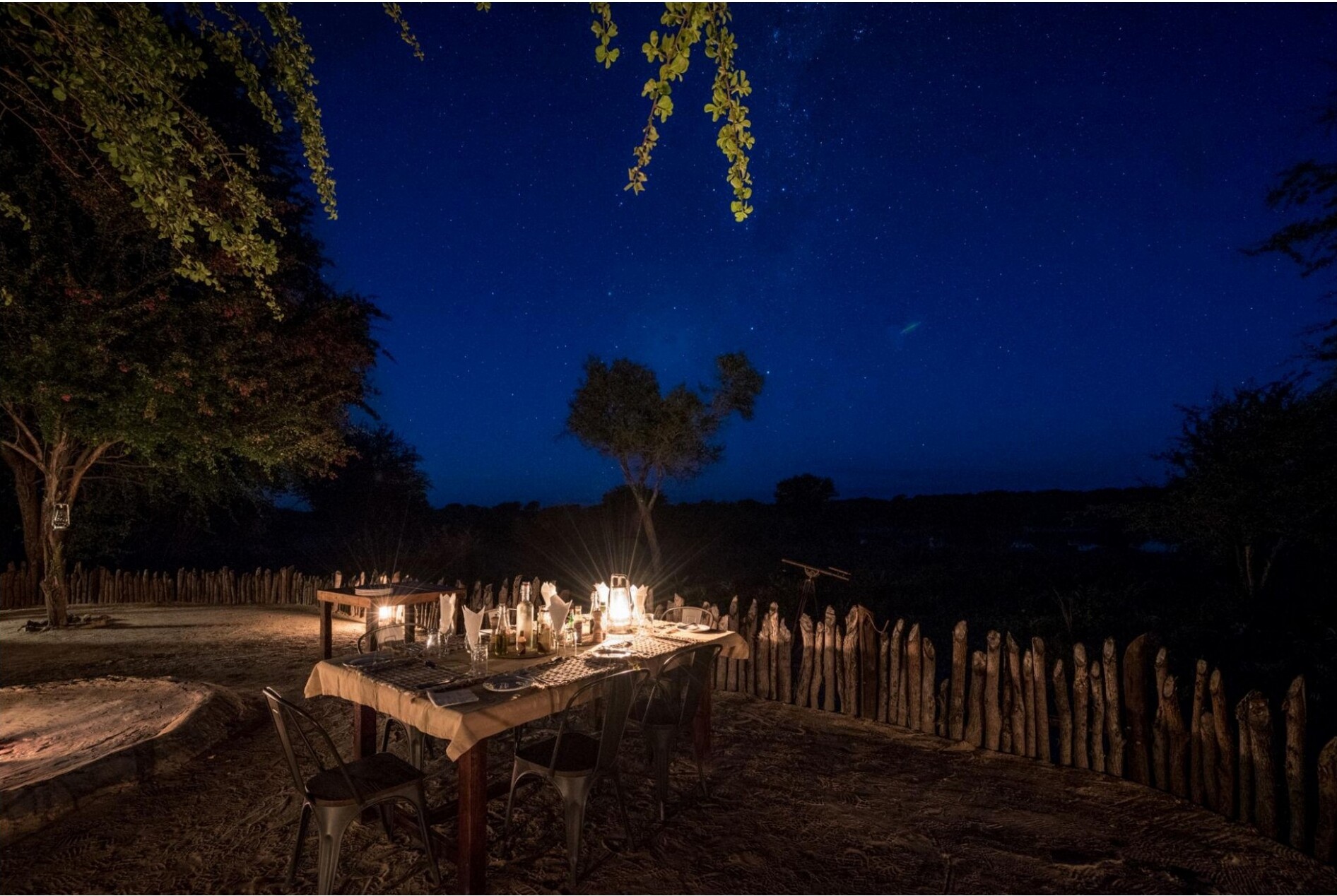 An outdoor dining table beneath a starry night sky