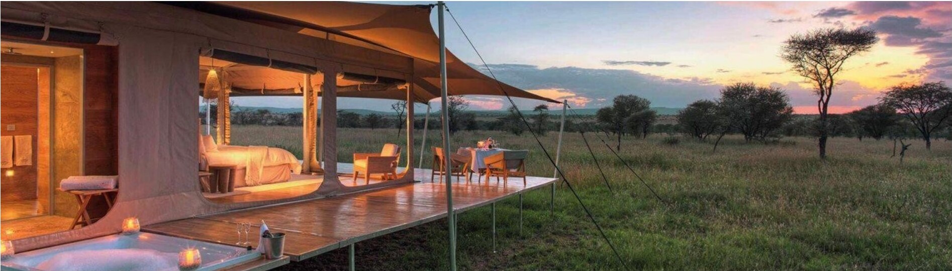 A luxury tented camp overlooking the savanna at sunset